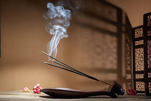 Smoke from burning incense sticks standing on lotus incense holder - Photo, Image