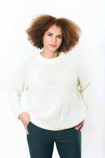Retrato de estudio de hermosa mujer afroamericana posando sobre fondo blanco, usando jersey - Foto, imagen