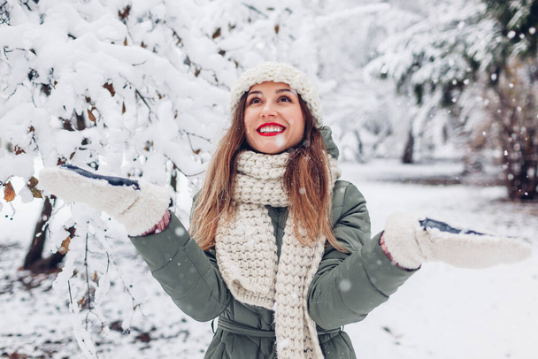 Onnellinen nuori nainen leikkii lunta luminen talvipuisto yllään lämmin neulotut vaatteet ja hauskaa ulkona nauttia säästä. Kausitoiminta - Valokuva, kuva