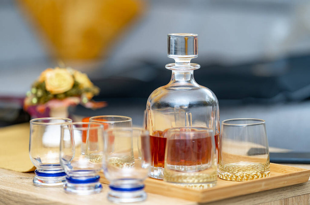 Cam viski şişesi ve masada bardaklar. - Fotoğraf, Görsel