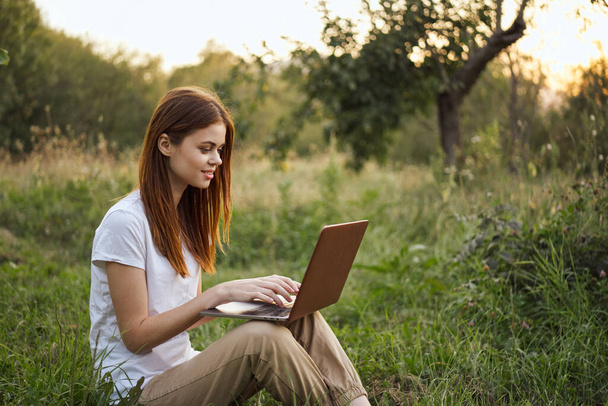 women outdoors in field with laptop leisure technology freedom - Фото, изображение