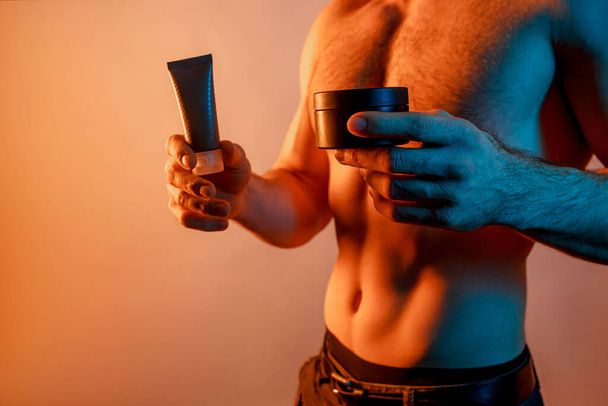 Обрізане зображення людини з косметичними кремами в руках
 - Фото, зображення