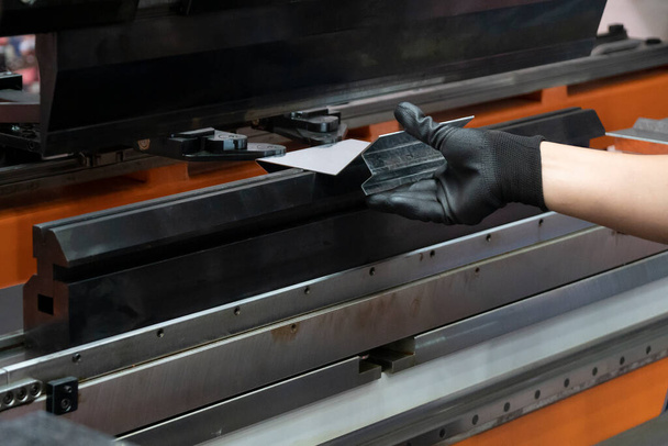 The hand of technician operator working with hydraulic press brake bending machine. The sheet metal working operation by skill operator. - Photo, Image