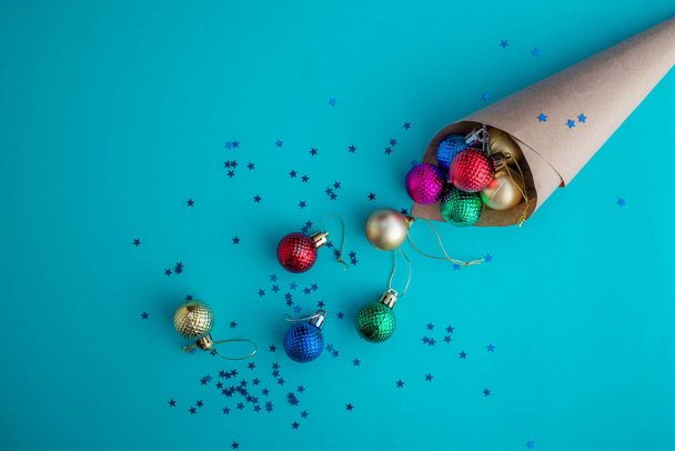 Composition vacances de Noël, vue de dessus du cône artisanal douché de boules colorées sur un fond bleu-vert avec espace de copie pour le texte. Pose plate. Hiver, modèle de carte postale
 - Photo, image