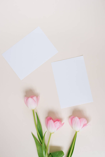 Mooie compositie lentebloemen. Blanco kader voor tekst, roze tulpen bloemen op beige achtergrond. Valentijnsdag, Pasen, Verjaardag, Gelukkige Vrouwendag. Vlakke lay, bovenaanzicht, kopieerruimte - Foto, afbeelding