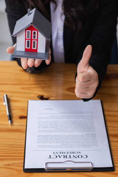 Immobilienmakler übergeben Häuser an Kunden, nachdem sie einen Kaufvertrag unterzeichnet haben, um den Verkauf abzuschließen, nachdem der Kunde einem Hauskaufvertrag mit dem Immobilienmakler zugestimmt hat.. - Foto, Bild