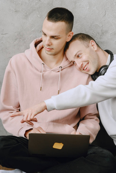 Gay couple consulting their travel plans together with a laptop - Valokuva, kuva