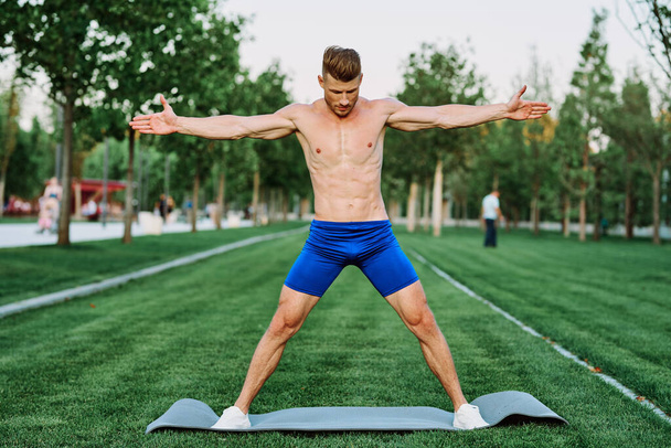 sporty muscular man goes in for sports in the park workout motivation - Foto, Imagem