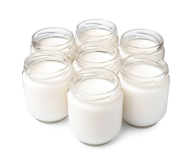 Glass jars with delicious homemade yogurt on white background - Photo, image