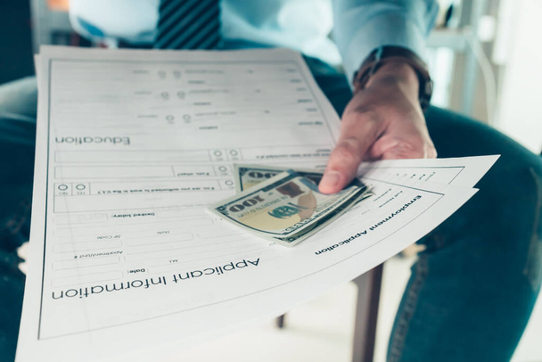 Men attach money to job applications. A man bribe for a new job - Фото, изображение