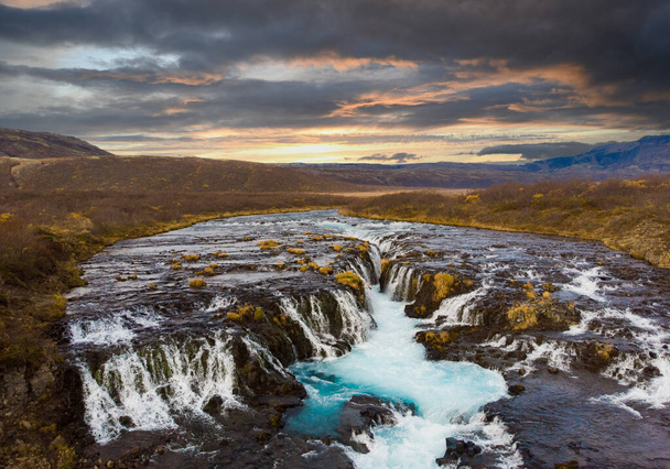 La cascada Bruarfoss en el sur de Islandia con una colorida puesta de sol un agua azul - Foto, imagen