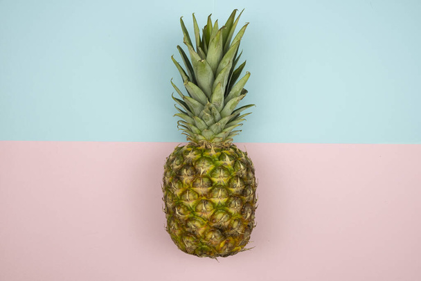A closeup of a pineapple on a pastel pink and blue background - Foto, Bild