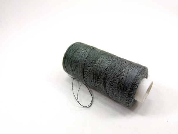 A closeup shot of green thread on a white background - Foto, afbeelding