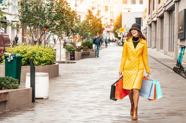 Beautiful woman with shopping bags walks at the street. Happy lifestyle, season discounts and sales concept. - Φωτογραφία, εικόνα