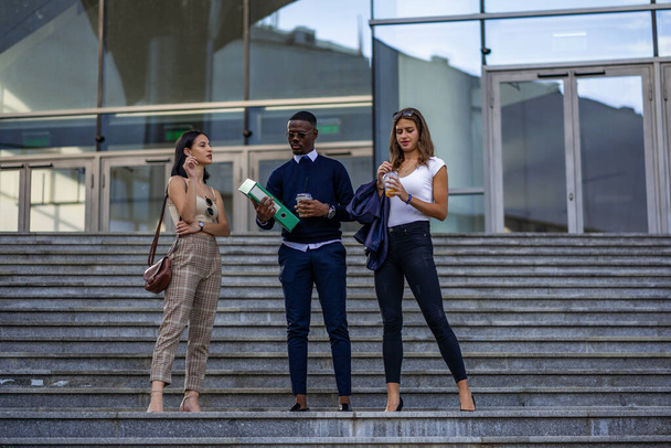 Drei multirassische Geschäftspartner machen gemeinsam vor ihrem Unternehmen Pause - Foto, Bild