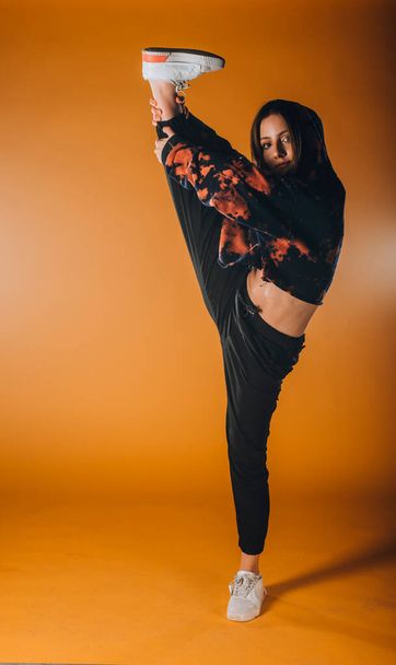Κομψή νεαρή κοπέλα που εκτελεί μια καλλιτεχνική χορογραφία χορού - Φωτογραφία, εικόνα