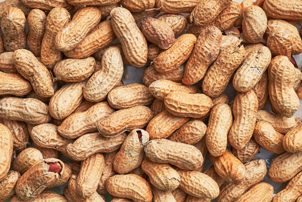 Gesunde geröstete ungeschälte Erdnüsse. Konsistenz brauner Nüsse - Foto, Bild