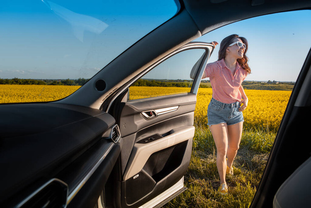 mujer parada para disfrutar de la puesta de sol en viaje por carretera viaje en coche - Foto, imagen