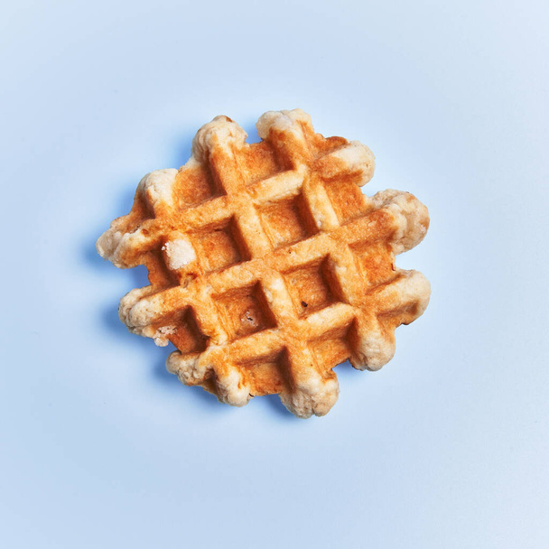  Single delicious waffle over blue background - Фото, изображение