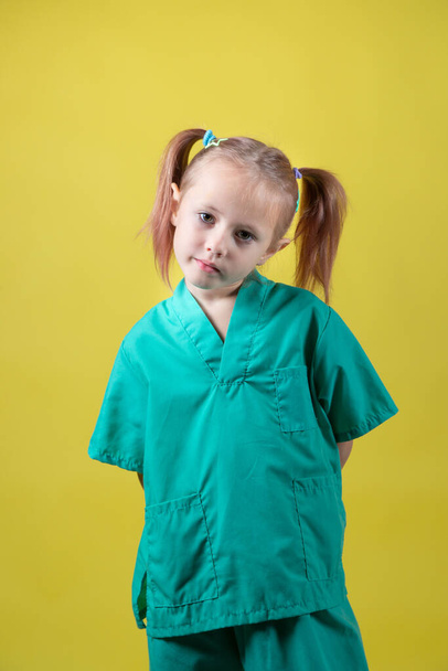 Portrait of little caucasian girl dressed in doctors green coat - Fotoğraf, Görsel