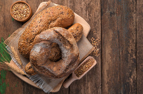 Whole-grain fresh bread on a wooden background. Top view, copy space. - Photo, Image