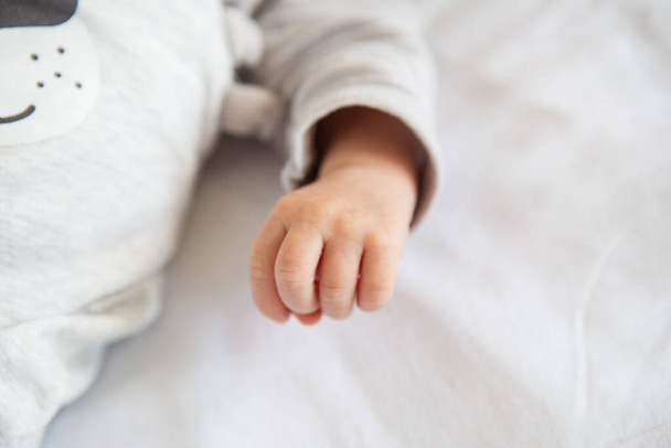 Yeni doğmuş bir bebeğin küçük elleri, bir yumruk, küçük parmaklar. Bir bebeğin hayatının ilk ayı. - Fotoğraf, Görsel