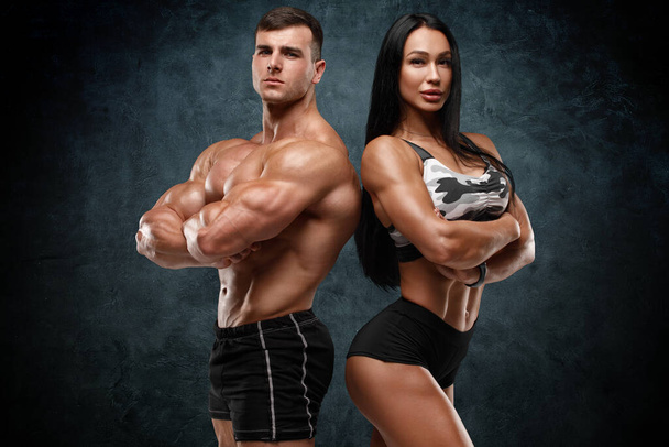 Sporty couple showing muscles. Muscular man and woman - Fotografie, Obrázek