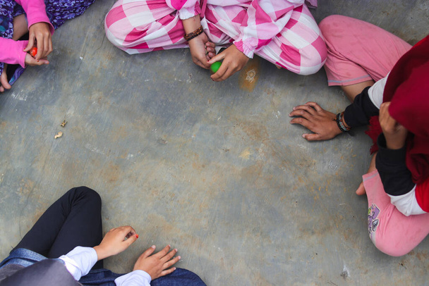 子供たちは、ジャワ中央部に由来するベークボール、ベークラン、またはベークレンと呼ばれる伝統的なインドネシアの子供向けゲームをプレイします。 - 写真・画像