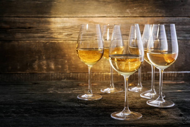 Освіжаюче біле вино в окулярах на дерев'яному тлі
 - Фото, зображення