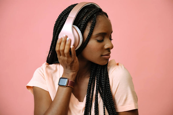 atractiva mujer africana escuchando música en auriculares  - Foto, Imagen