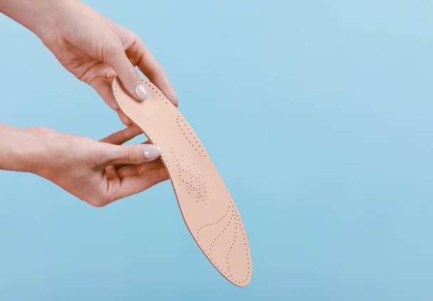 Orthopedic insole isolated on a blue background. Medical insoles. Treatment and prevention of flat feet and foot diseases. Foot care, feet comfort. Wear comfortable shoes. Flat Feet Correction - Foto, imagen