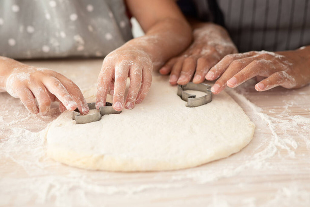 Μητέρα και κόρη χέρια κόβοντας διαφορετικές μορφές μπισκότων του Dough, Closeup - Φωτογραφία, εικόνα