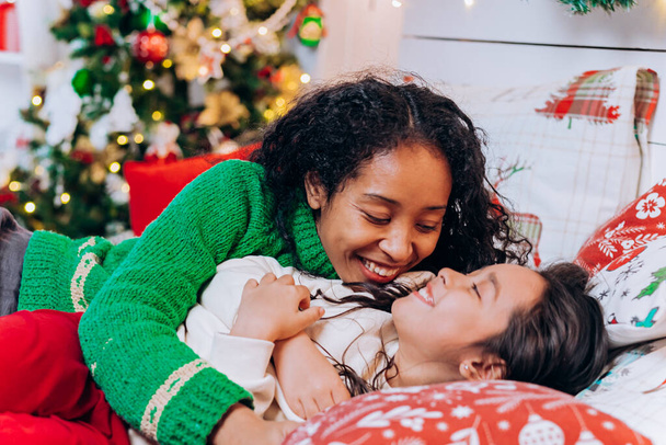madre afroamericana pone hija a dormir en Navidad - Foto, imagen