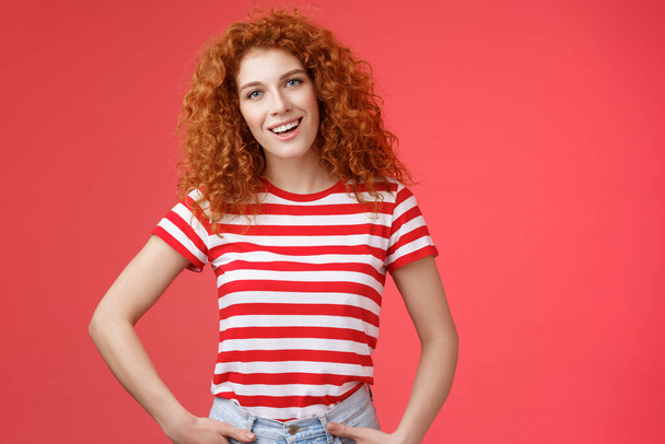 How hanging. Friendly carefree redhead curly-haired relaxed outgoing woman speaking casually entertained happy mood hold hands jeans pockets tilt head intrigued, curiously look camera - Photo, Image