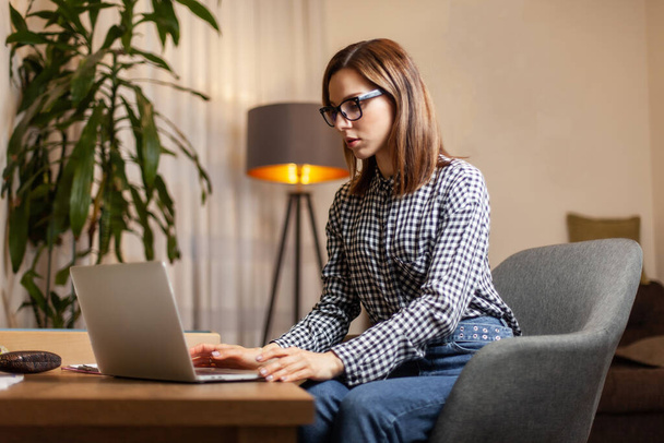Fiatal vonzó nő használja laptop az otthoni irodájában - Fotó, kép