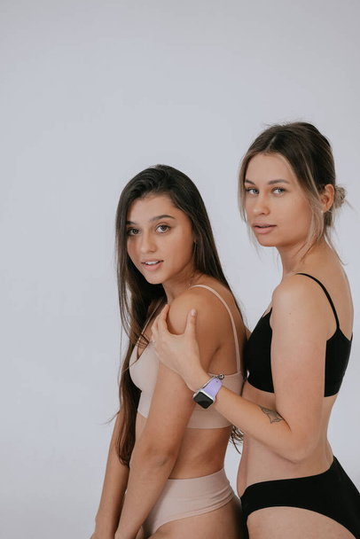 Two diverse models wearing underwear stand side to the camera - Fotografie, Obrázek
