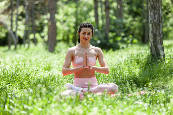 Young beautiful woman meditating in the park or forest - Photo, Image