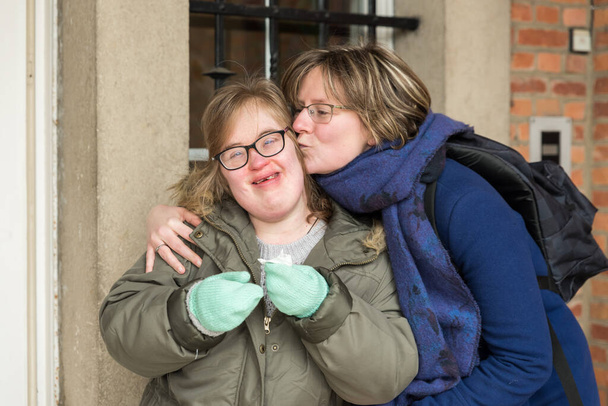 Tienen, Flanders  Belgium - 07 20 2018: Portrait of a young white woman kissing a woman with Down Syndrome. - Фото, зображення