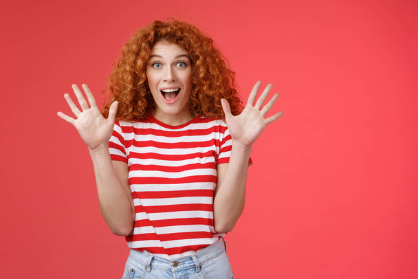Extremely wonderful news she excited. Thrilled emotive gorgeous redhead woman scream amazed awesome surprise raise hands waving impressed open mouth stare charmed fascinated red background - Photo, Image