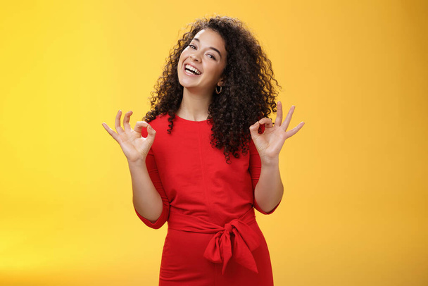Charming girl living dream standing happy and satisfied as liking new apartment rent with boyfriend showing okay gesture and tilting head with broad smile approving cool place over yellow background - Photo, Image