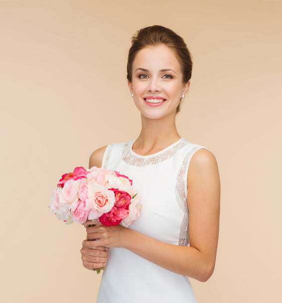 smiling woman in white dress with bouquet of roses - 写真・画像
