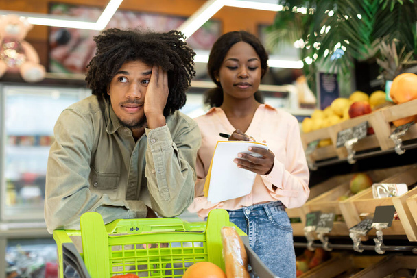 Boldogtalan fekete pár Számlálás árak Bevásárlólista a szupermarketben - Fotó, kép