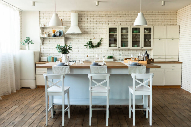 Light sunny kitchen or dining room in Scandinavian style. Modern interior with white kitchen furniture. Home decor - Photo, Image
