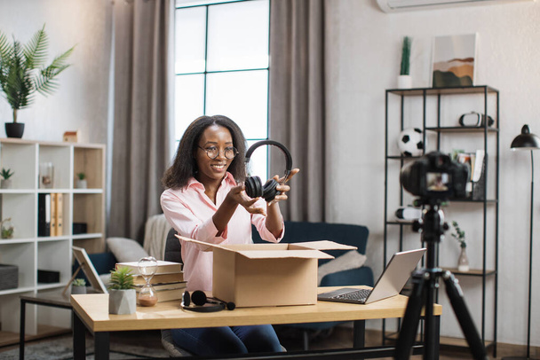 African woman recording video while unpacking box - Photo, Image