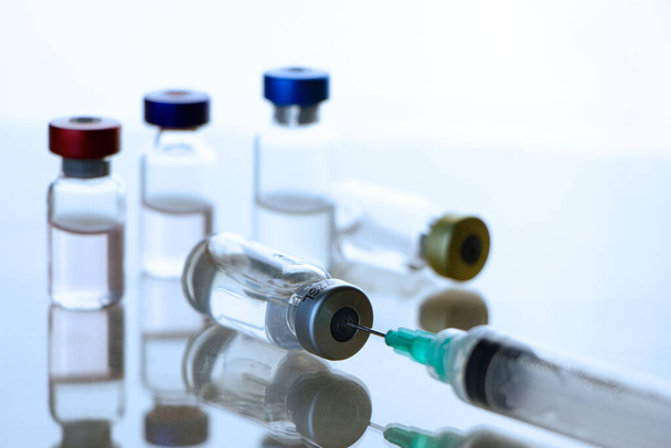 Vacunas, vaccine y jeringas en recipiente. En un laboratorio. Ciencia humana - Foto, Bild