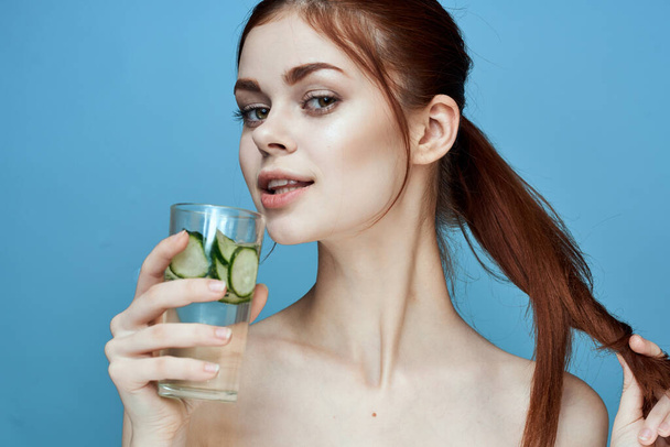 woman with bared shoulders cucumber health drink blue background - Fotografie, Obrázek