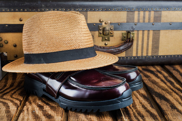 hat shoes and in a vintage suitcase on a wooden table. close-up - Photo, image
