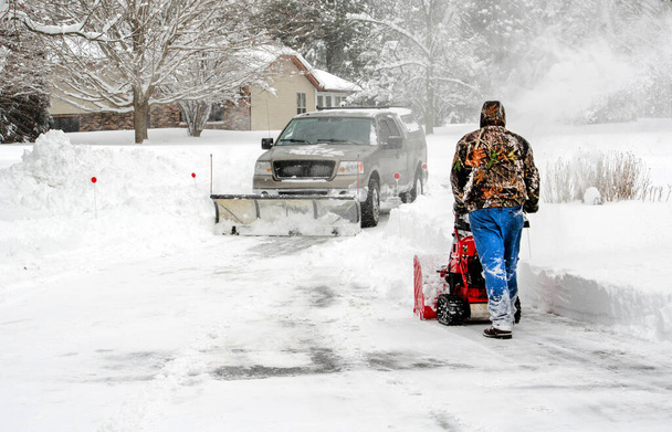 команда с снегоочистителем и воздуходувом усердно трудится, чтобы очистить дорожки так быстро, как они могут - Фото, изображение