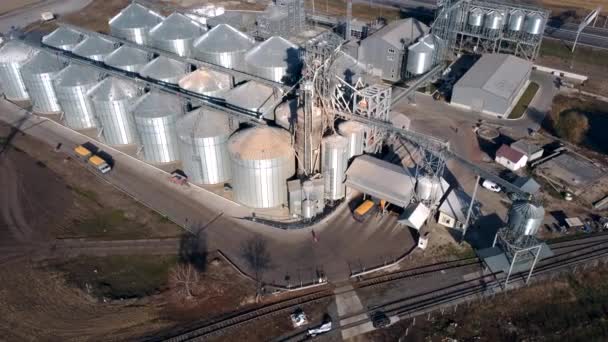 Caminhão cheio de passeios de grãos perto de grandes silos metálicos de elevador de grãos no dia ensolarado. - Filmagem, Vídeo
