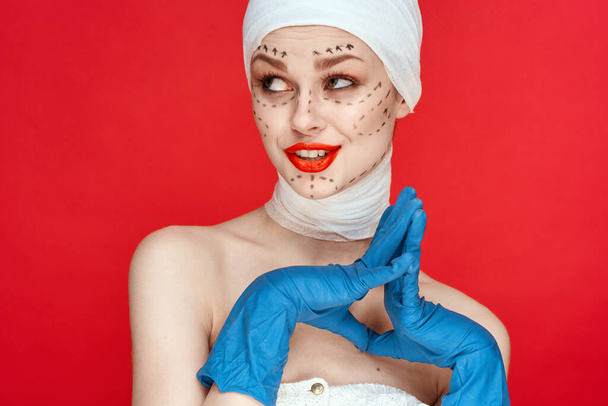 mooie vrouw rode lippen plastische chirurgie operatie kale schouders rode achtergrond - Foto, afbeelding